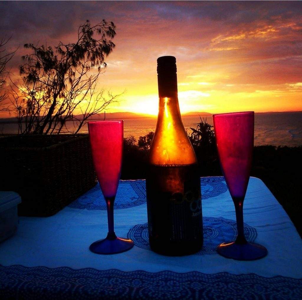 Wine and glasses with sunset in the background